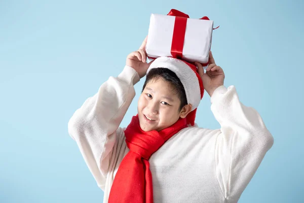 Asiatiska preteen pojke som håller presentförpackningar på blå bakgrund, New Yea — Stockfoto