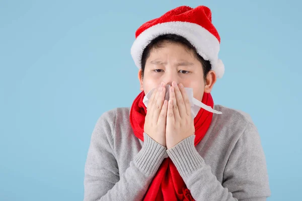 Asiatiska preteen pojke bär Santa hatt och använda servett med blå b — Stockfoto