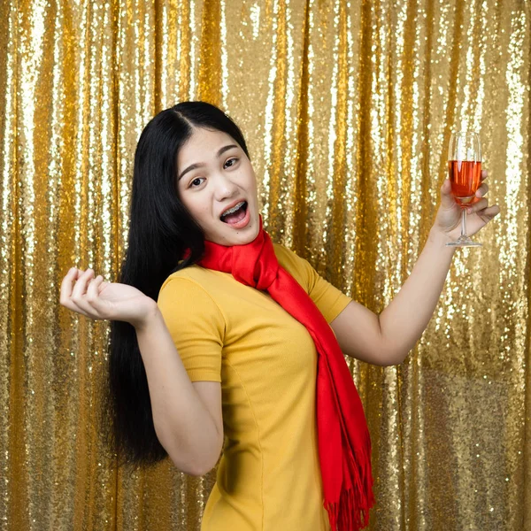 Heureuse femme asiatique avec écharpe rouge et boire du vin rouge sur or g — Photo
