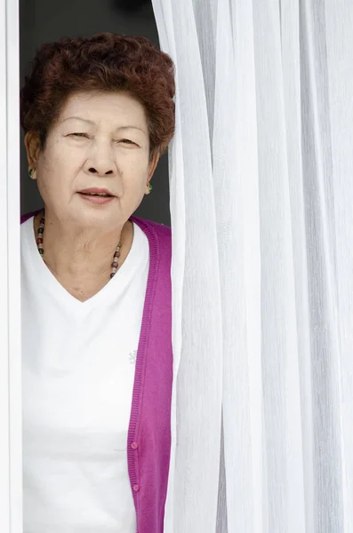 Femme âgée ouvrant porte d'entrée de la maison — Photo