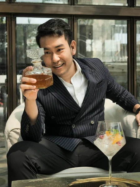 Handsome Asian businessman drinking fusion tea in cafe, lifestyl