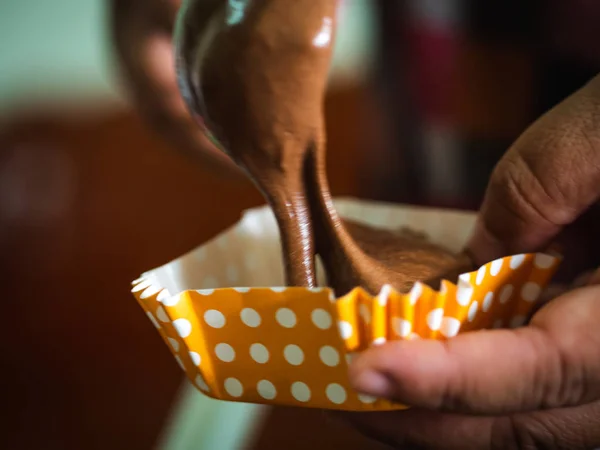Bewegungsunschärfe bei der Verarbeitung hausgemachter Schokoladen-Cupcakes auf Tablett. — Stockfoto