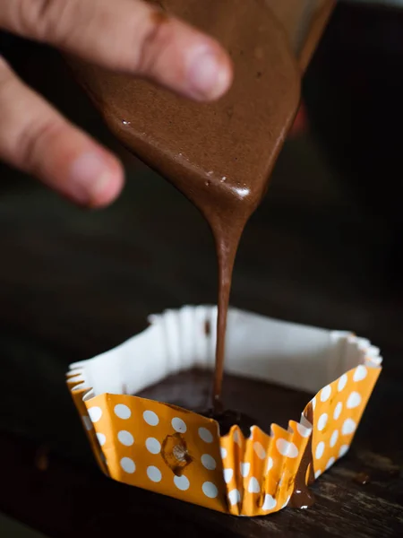 Bewegungsunschärfe bei der Verarbeitung hausgemachter Schoko-Cupcakes auf dem Tisch. — Stockfoto