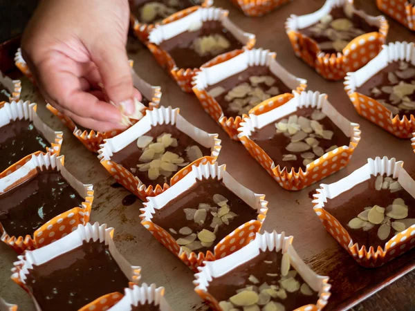 Bewegungsunschärfe Verbreitung von Mandeln in Scheiben geschnitten auf hausgemachte Schokolade Cupca — Stockfoto