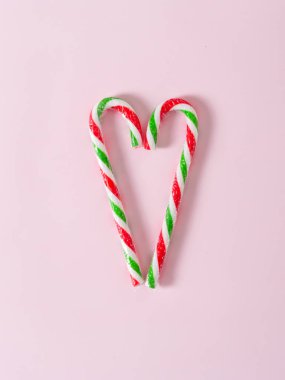 Kalp şeklinde Noel şekeri pembe arka planda fotokopi alanı ile.