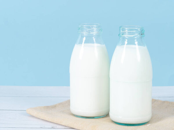 Бутылка молока на столе с синим фоном
.