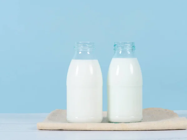 Bouteille de lait sur table avec fond bleu . — Photo