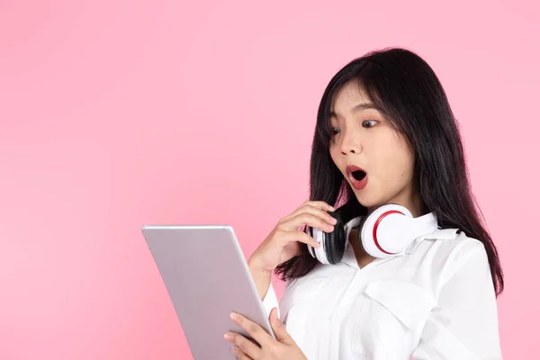 Surpreendente Asiático adolescente menina olhando para tablet em rosa backgro — Fotografia de Stock