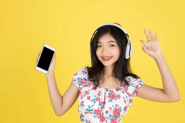 Heureux asiatique adolescent fille à l'aide casque et smartphone sur hurler — Photo