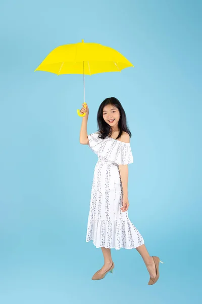 Asiatico donna indossare bianco lungo abito holding giallo ombrello su — Foto Stock