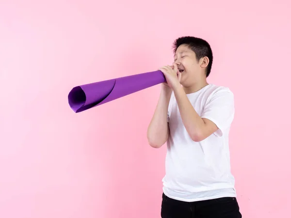 Asijské preteen chlapec pomocí fialový papír megaphone na růžové pozadí — Stock fotografie
