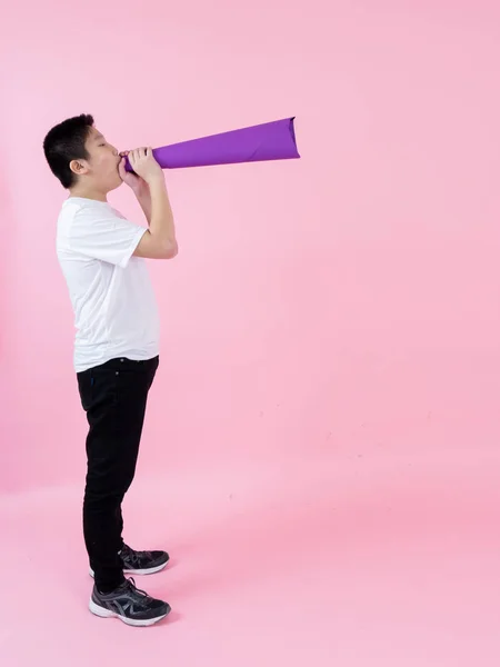 Asijské preteen chlapec pomocí fialový papír megaphone na růžové pozadí — Stock fotografie