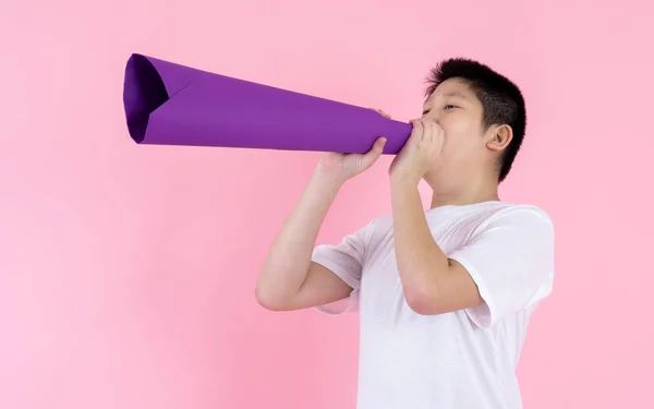 Asijské preteen chlapec pomocí fialový papír megaphone na růžové pozadí — Stock fotografie