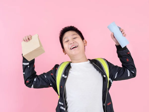 Asiático preadolescente chico mostrando bolsa de almuerzo y bebida botella, listo para s —  Fotos de Stock