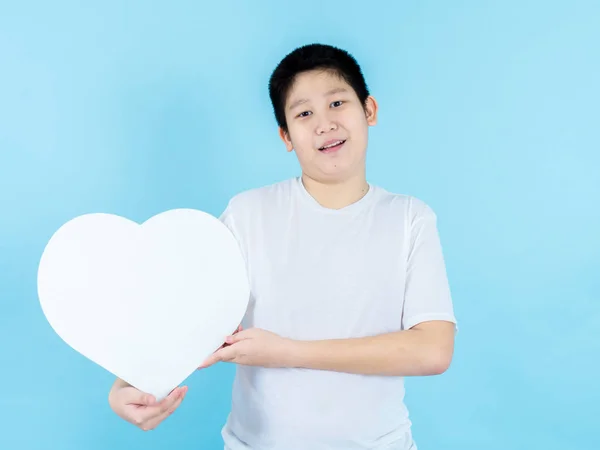 Asiático preadolescente chico holding blanco corazón forma discurso burbuja en blu — Foto de Stock