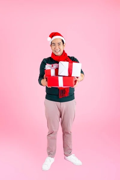 身穿绿色毛衣头戴圣诞礼帽的快乐亚洲人 — 图库照片