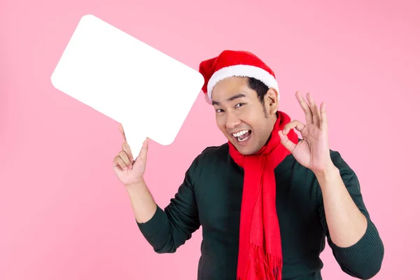 身穿毛衣头戴圣诞礼帽的亚洲男人拿着话筒 — 图库照片