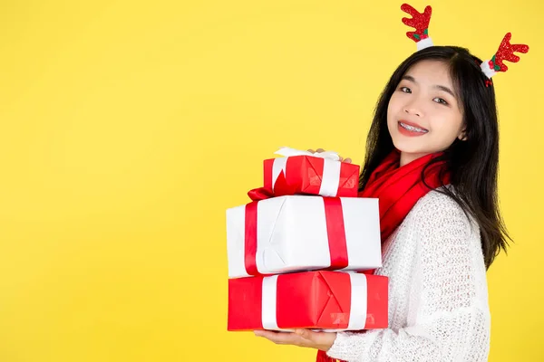 快乐的亚洲少女提着礼品盒站在黄色的靠背上 — 图库照片