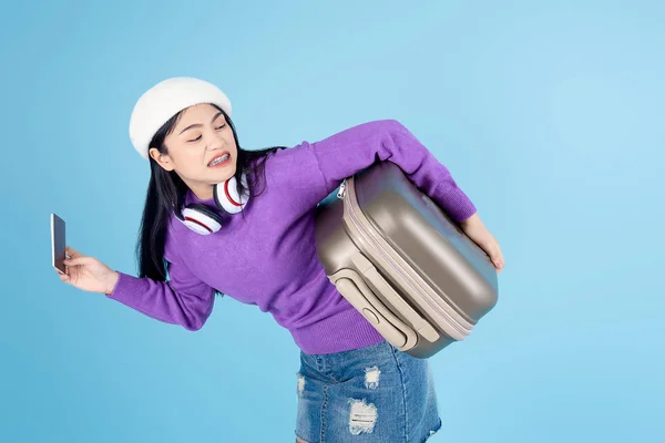 Mulher asiática engraçada vestindo camisola transportando bagagem correndo em bl — Fotografia de Stock