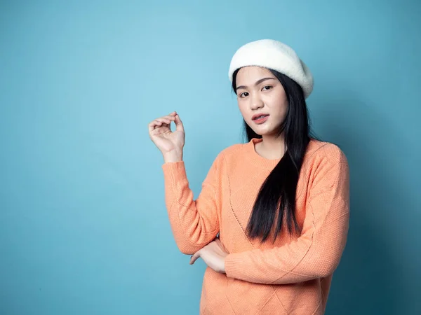 Femme asiatique portant un chandail orange sur fond bleu, mode de vie — Photo