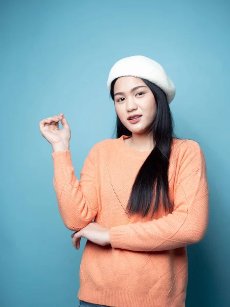 Mavi arka planda turuncu süveter giyen Asyalı kadın, yaşam tarzı — Stok fotoğraf
