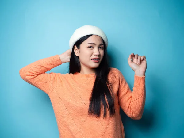 Femme asiatique portant un chandail orange sur fond bleu, mode de vie — Photo