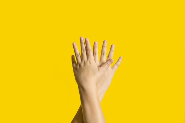 Right and left hands calling for help on yellow background. — Stock Photo, Image