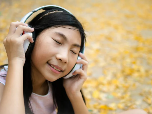Movimento borrão menina asiática vestindo fone de ouvido e sentado no l amarelo — Fotografia de Stock