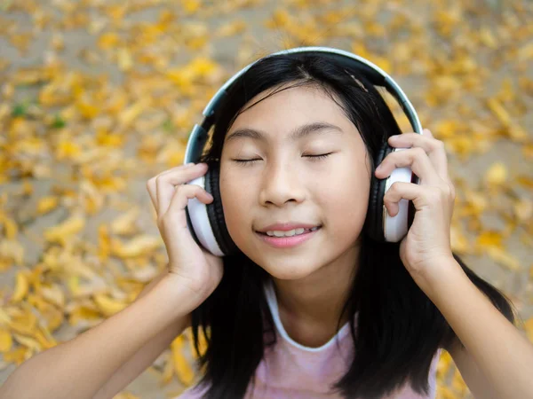 Movimento borrão menina asiática vestindo fone de ouvido e sentado no l amarelo — Fotografia de Stock