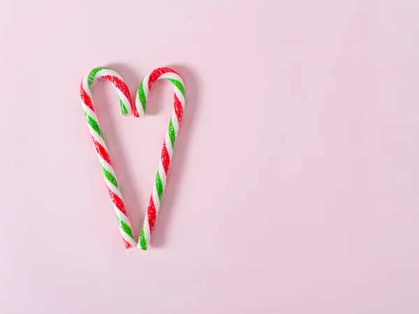 Caramelle di Natale a forma di cuore su sfondo rosa con spazio copia . — Foto Stock