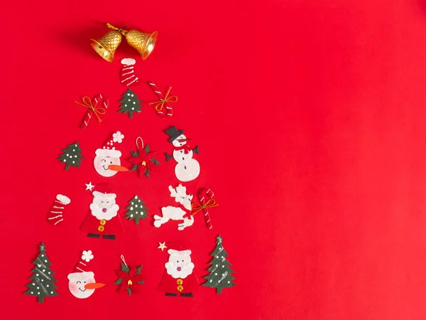 Objetos navideños expuestos en forma de árbol sobre fondo rojo —  Fotos de Stock