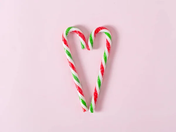 Caramelle di Natale a forma di cuore su sfondo rosa con spazio copia . — Foto Stock