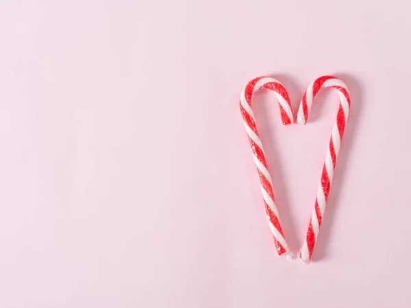 Caramelle di Natale a forma di cuore su sfondo rosa con spazio copia . — Foto Stock