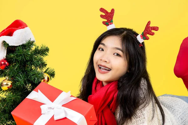 Asian teenager girl wearing Santa hat lying on floor with Christ — ストック写真
