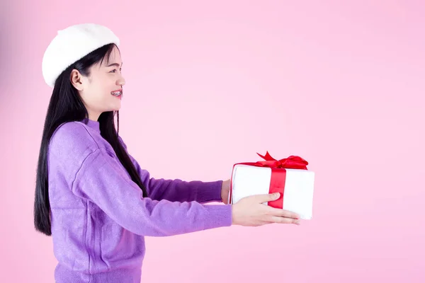 快乐的亚洲女人穿着紫色毛衣 带着粉色背景的礼品盒 — 图库照片