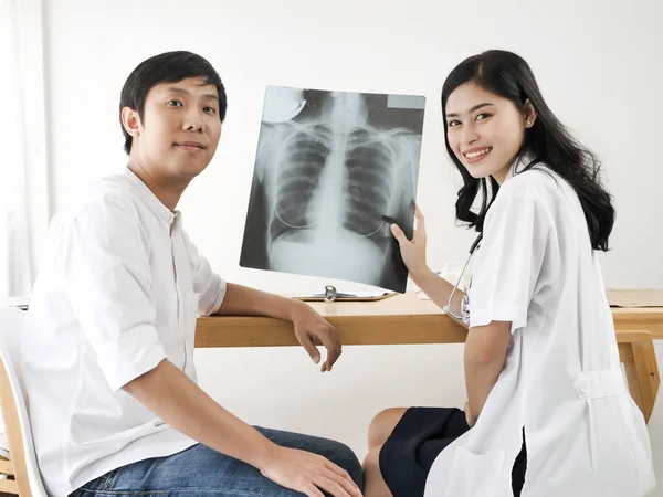 Asiatisk Læge Viser Røntgenresultater Til Hendes Patient - Stock-foto