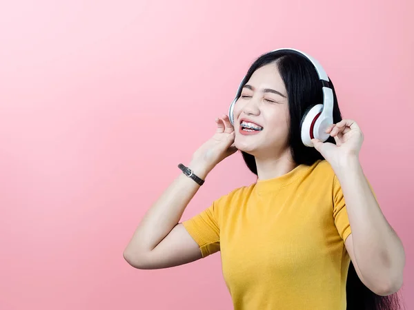 Glückliche Asiatische Frau Gelbem Kleid Mit Kopfhörer Mit Rosa Hintergrund — Stockfoto