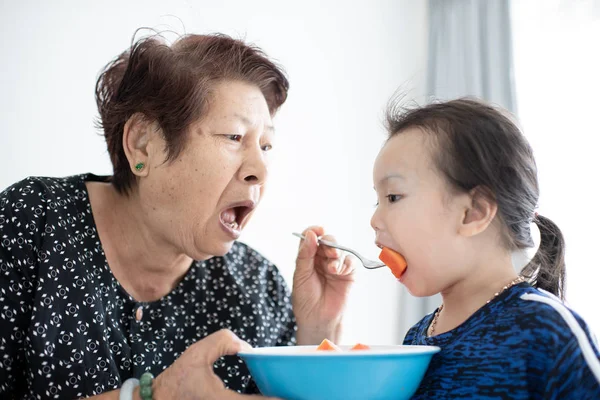 Büyükanne Ile Olgun Papaya Çocuğunu Besleme Dilimlenmiş — Stok fotoğraf