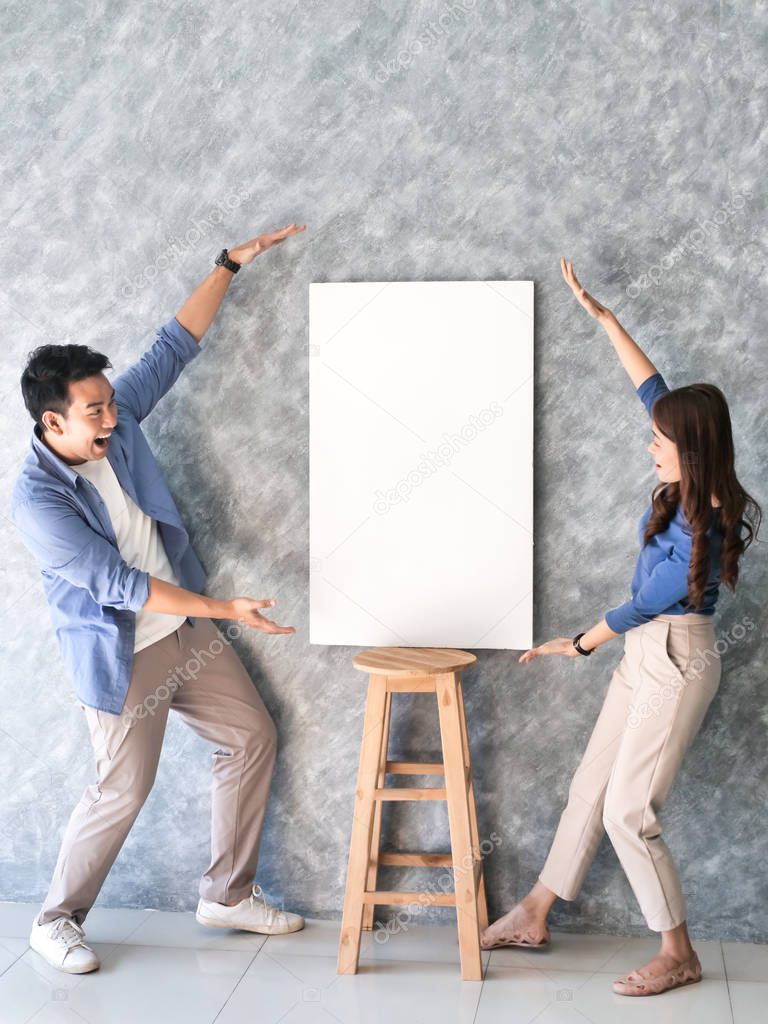 Happy Asian couple present blank white board with gray backbround.