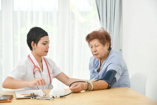 Asiatico Medico Checking Suo Paziente Vecchio Donna Ufficio — Foto Stock