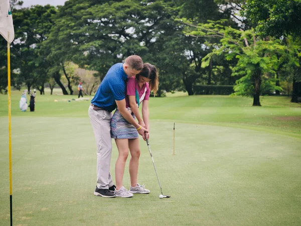 高尔夫教授他的女朋友打高尔夫 生活方式的概念 — 图库照片