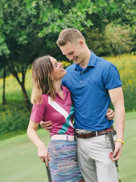 ハッピーゴルファーカップル抱擁と一緒に話す緑のフィールド屋外で — ストック写真