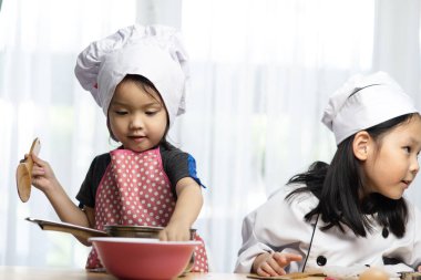 Mutlu Asyalı kızlar, evde aşçılık oynuyorlar..