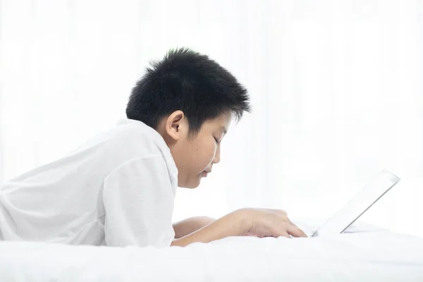 Skrattande Asiatiska Preteen Pojke Som Ligger Sängen Och Använder Laptop — Stockfoto