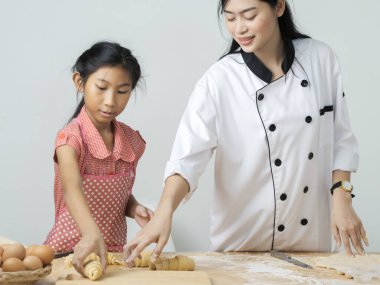 Asyalı kız şeften kruvasan işlemeyi öğreniyor. Yaşam tarzı konsepti..