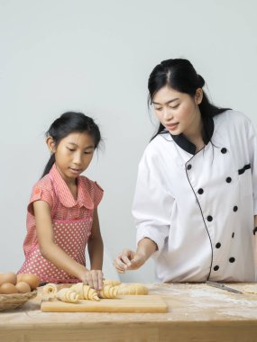 Asyalı kız şeften kruvasan işlemeyi öğreniyor. Yaşam tarzı konsepti..