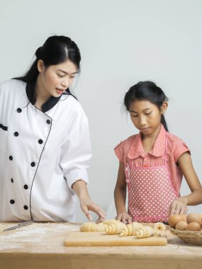 Asyalı kız şeften kruvasan işlemeyi öğreniyor. Yaşam tarzı konsepti..