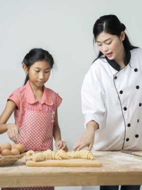 Asyalı kız şeften kruvasan işlemeyi öğreniyor. Yaşam tarzı konsepti..