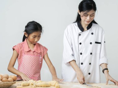 Asyalı kız şeften kruvasan işlemeyi öğreniyor. Yaşam tarzı konsepti..