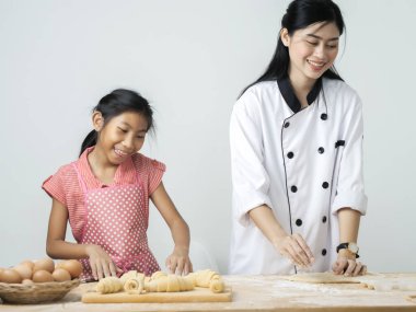 Asyalı kız şeften kruvasan işlemeyi öğreniyor. Yaşam tarzı konsepti..